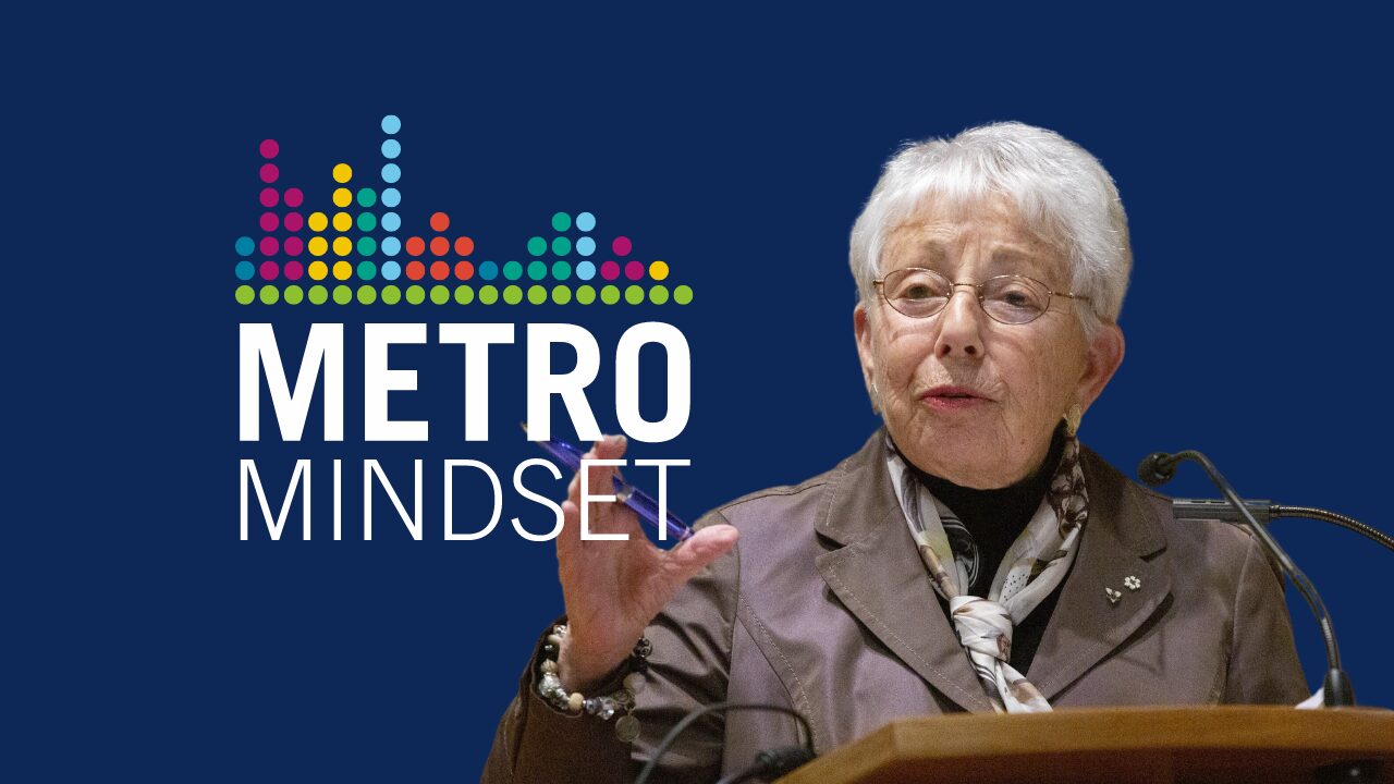 Dr. Anne Golden on a podium. Metro Mindset logo.