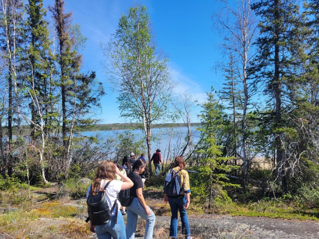 Students walk along Yellowknife shoreline