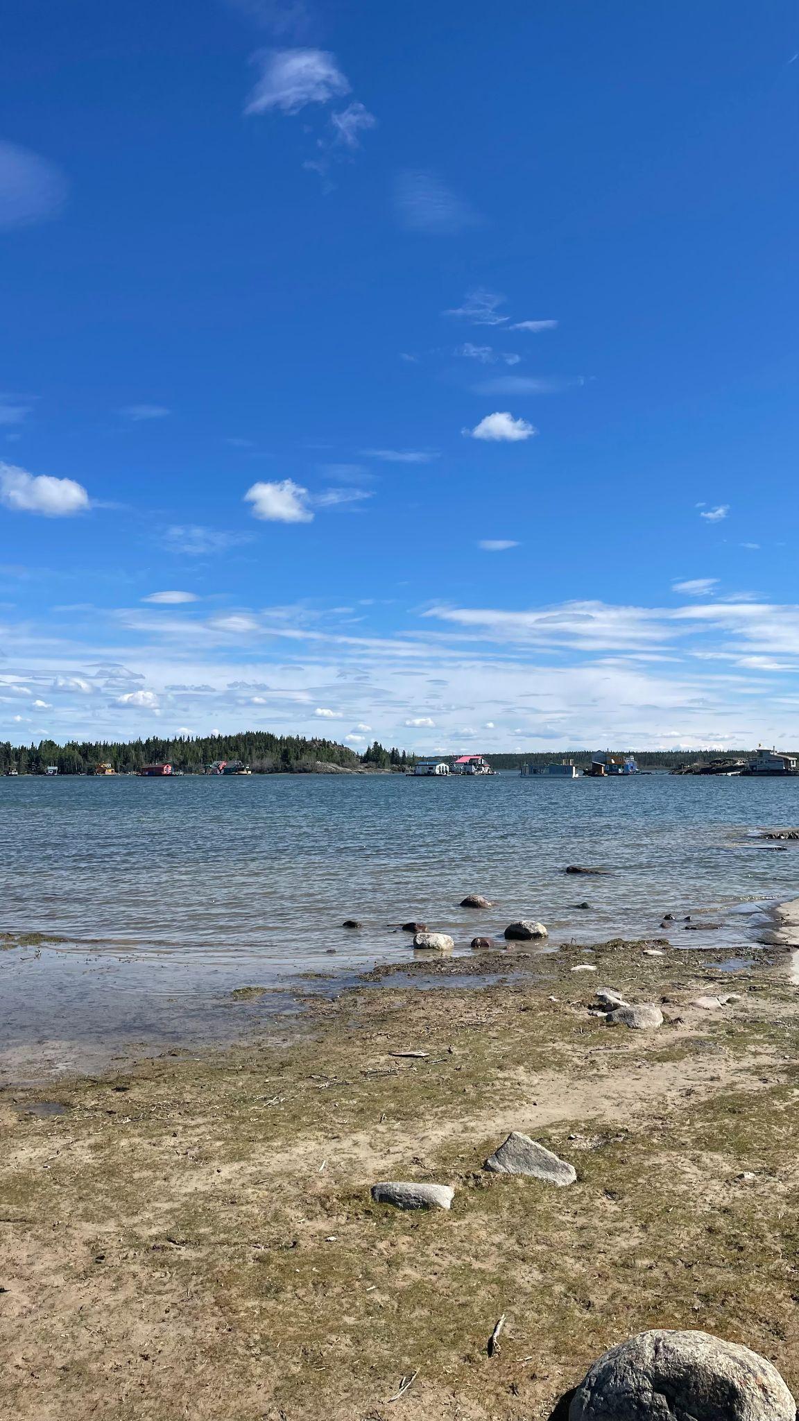 Wide shot of houseboats Great Slave Lake under sunny skies