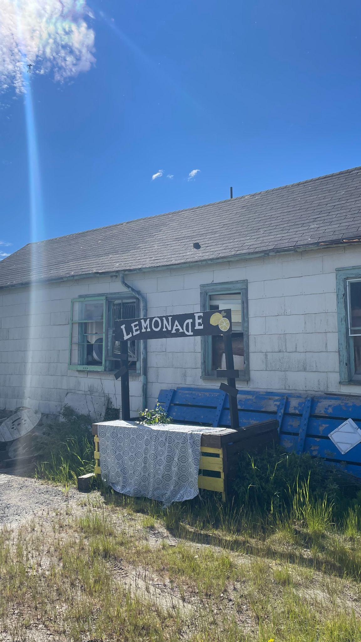 Small lemonade stand outside of a house